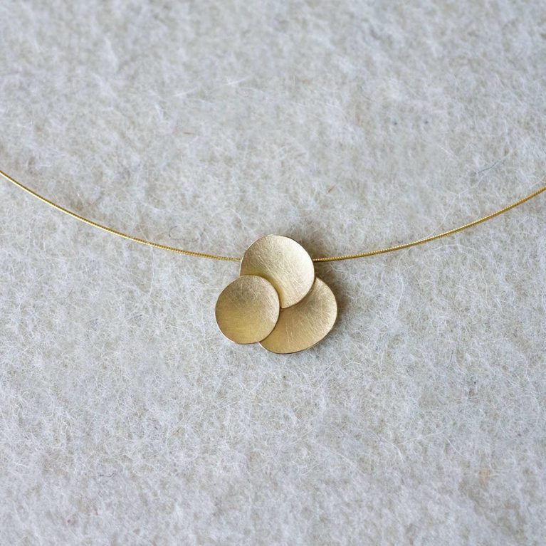 Colgante de oro con tres discos superpuestos en diseño contemporáneo