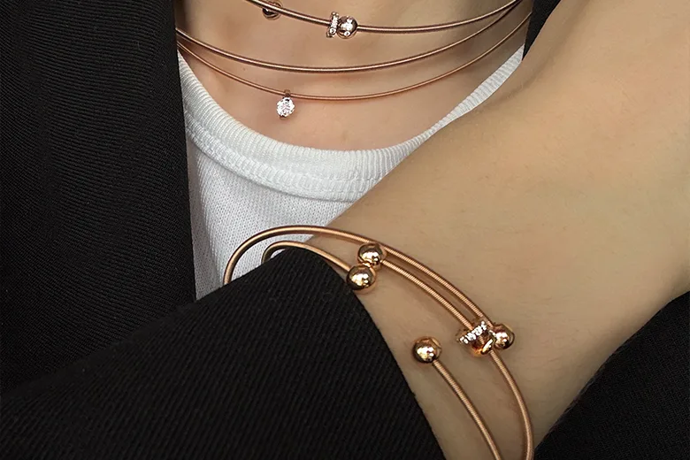 collar y pulsera Niessing Coil en oro llevados por mujer diseño sin cierre joyería contemporánea