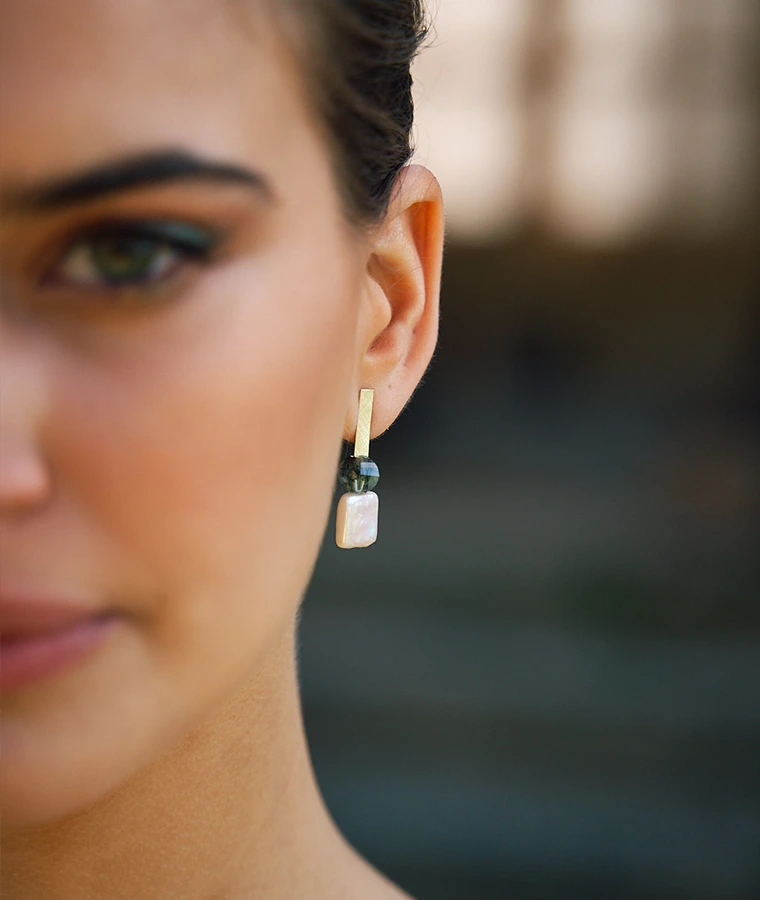 Primer plano de pendiente de novia con diseño geométrico y perla sobre modelo de Pepe Alba Jewelry