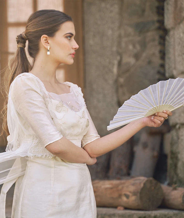 Mujer con vestido claro y pendientes de novia de diseño en una escena editorial de Pepe Alba Jewelry